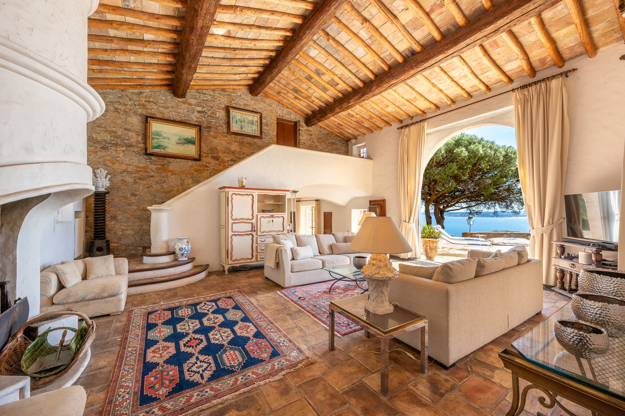 Grand salon avec cheminée et poutres apparentes